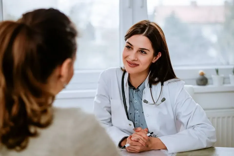 FNP Smiling at Adult Patient in Medical Office